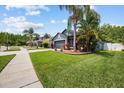 Well-maintained single Gathering home with lush lawn, landscaped garden beds, and tropical palm trees at 18516 Snowdonia Dr, Land O Lakes, FL 34638