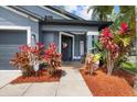 Inviting home entrance with colorful landscaping and a welcoming front porch sign at 18516 Snowdonia Dr, Land O Lakes, FL 34638