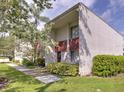 Townhouse exterior with green grass and a sidewalk leading up to the front door at 1877 Pine Cone Cir, Clearwater, FL 33760