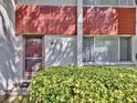 Exterior facade of a townhome featuring a front door, a colorful brick design, and lush landscaping at 1877 Pine Cone Cir, Clearwater, FL 33760