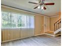 Bright living room with vinyl floors, fan, and a large window letting in natural light at 1877 Pine Cone Cir, Clearwater, FL 33760