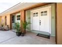 Inviting entryway with double doors, decorative plants, and a neutral color scheme at 1913 Libby Ct, Holiday, FL 34690
