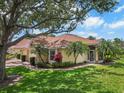 Inviting villa with a screened entry, lush lawn, and mature landscaping at 2516 New Haven Cir, Sun City Center, FL 33573