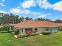 Beautiful villa with well-manicured lawn, colorful flowers, and screened lanai at 2516 New Haven Cir, Sun City Center, FL 33573