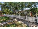 Wide view of a home surrounded by mature trees and a beautiful white picket fence at 2710 10Th N St, St Petersburg, FL 33702