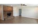 Inviting living room featuring a brick fireplace, tiled floors, and neutral paint at 38535 Clinton Ave, Dade City, FL 33525