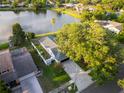 Aerial view of home by a lake showing the lot, paver driveway, mature trees, and fenced backyard at 3925 Dunaire Dr, Valrico, FL 33596