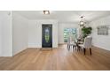 Dining area with wood floors, black front door, updated light fixture, white walls and table at 3925 Dunaire Dr, Valrico, FL 33596