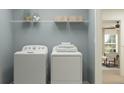 This efficient laundry room features a front load washer and dryer and a shelf with decorative baskets at 4511 S Manhattan Ave # 3, Tampa, FL 33611