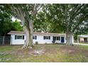 Charming single-story home featuring white siding, a blue front door, and mature trees at 4650 32Nd N Ave, St Petersburg, FL 33713