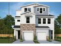 New two-story home with white siding, stone accents, and a two-car garage at 503 W Warren Ave # 1, Tampa, FL 33624