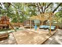 Expansive backyard with custom pergola, play area, and mature trees at 5149 4Th St, Zephyrhills, FL 33542