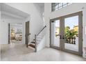 Bright foyer showcasing marble floors, a staircase, and double doors with views of the outdoors at 6024 Kipps Colony E Dr, Gulfport, FL 33707