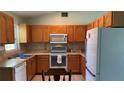 Classic kitchen with wood cabinets, white appliances, and tiled backsplash creating a warm, functional space at 6405 Klaus Ct, Port Charlotte, FL 33981