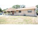 Beige single-story home features a covered carport and a simple, tidy lawn at 6514 La Mesa Cir, Tampa, FL 33634