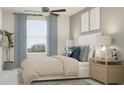 Bright bedroom with comfortable queen bed, soft blue accents, and plenty of natural light at 10193 Trumpet Honeysuckle Way, San Antonio, FL 33576
