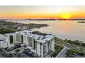 Stunning aerial view of modern condo building situated on the waterfront, with beautiful sunrise and cityscape at 1020 Sunset Point Rd # 712, Clearwater, FL 33755
