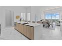 Open-concept kitchen featuring a large island with modern countertops and views of the dining and living area at 1020 Sunset Point Rd # 712, Clearwater, FL 33755