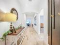 Bright hallway with wood-look tile flooring, arched doorways, and console table with decor at 12010 Jackson Landing Pl, Tampa, FL 33624