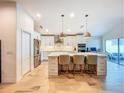 Open kitchen showcasing a large island with seating, pendant lighting, and stainless steel appliances at 12010 Jackson Landing Pl, Tampa, FL 33624