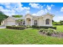 Beautiful curb appeal with manicured lawn, front door entrance and three-car garage at 1212 Baycove Ln, Lutz, FL 33549