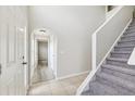 Wide shot of the foyer showing the front door and staircase with a carpeted runner at 12470 Elgin Blvd, Spring Hill, FL 34609