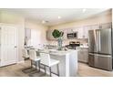 Modern kitchen featuring stainless steel appliances, an island with seating, and gray cabinets at 12842 Canter Call Rd, Lithia, FL 33547