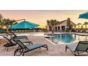Resort-style pool area with lounge chairs, umbrellas, and a clubhouse, perfect for leisure and recreation at 14643 Brumby Ridge Ave, Lithia, FL 33547