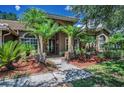 Charming single-story house featuring a landscaped yard, a tiled roof, and a front door at 1516 E Lake Woodlands Pkwy, Oldsmar, FL 34677