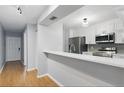 Modern kitchen featuring stainless steel appliances, white cabinets, and a breakfast bar at 16109 Rambling Vine E Dr, Tampa, FL 33624