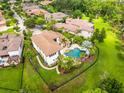 Aerial shot highlighting a private backyard oasis with a pool, spa, lush greenery, and a charming fenced perimeter at 17301 Ladera Estates Blvd, Lutz, FL 33548
