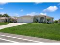 Charming single Gathering home with a lush green lawn and a three-car garage at 180 Rotonda N Blvd, Rotonda West, FL 33947
