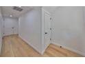 Clean hallway featuring hardwood floors, white walls, and modern doors at 1801 N Morgan St # 5, Tampa, FL 33602
