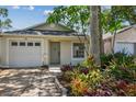 Charming single-story home featuring lush landscaping, a one-car garage, and a welcoming front entrance at 2742 Wilson Ct, Palm Harbor, FL 34684