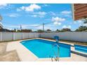 Sparkling in-ground pool with a white fence, perfect for relaxation and recreation at 3215 58Th N St, St Petersburg, FL 33710