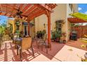 Outdoor patio with a wooden pergola, fan, seating, grill, and potted plants at 356 20Th Ne Ave, St Petersburg, FL 33704