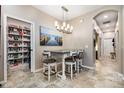 Dining area featuring stylish chandelier, adjacent pantry, seating for four, and hallway access at 3904 Bridlecrest Ln, Bradenton, FL 34209
