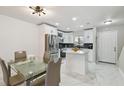 Bright kitchen with stainless steel appliances, white cabinets, and dining table at 4017 Cedar Limb Ct, Tampa, FL 33614