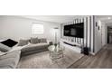 Spacious living room featuring a comfortable gray couch, modern lighting, and sleek entertainment center at 4521 W North St, Tampa, FL 33614