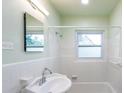 Well-lit bathroom featuring a vintage sink, tiled walls and combined bathtub and shower at 4611 17Th N Ave, St Petersburg, FL 33713