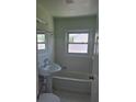 Bathroom with white tiled walls, pedestal sink, and tub at 4611 17Th N Ave, St Petersburg, FL 33713