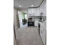 Modern kitchen featuring white cabinets, stainless steel appliances, and gray backsplash at 4611 17Th N Ave, St Petersburg, FL 33713