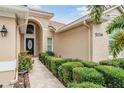 Inviting front entrance with decorative door, manicured hedges and tile walkway to front door at 5156 Pinnacle Dr, Oldsmar, FL 34677