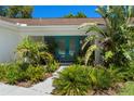 Landscaped front entrance with vibrant plants and stylish double doors, creating a welcoming approach at 60 Lakeview Ct, Palm Harbor, FL 34683