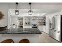 Modern kitchen boasts stainless steel appliances, an island, pendant lighting, and open shelving at 60 Lakeview Ct, Palm Harbor, FL 34683