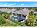 Aerial view of a private backyard oasis with a sparkling pool, patio area, and lush landscaping at 6909 Crestpoint Dr, Apollo Beach, FL 33572