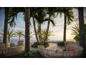 Relaxing waterfront seating area with tropical plants, perfect for enjoying the sunset at 805 S Gulfview Blvd # 701B, Clearwater, FL 33767