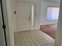 Inviting foyer with tiled floor, a white front door, and a glimpse into the living area at 8130 Shalom Dr, Spring Hill, FL 34606