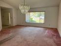 Spacious living room featuring a chandelier and a large window providing natural light at 8130 Shalom Dr, Spring Hill, FL 34606