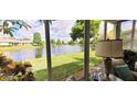 Relaxing lanai view showcasing a serene lake, lush greenery, and beautiful landscaping at 834 Tremont Greens Ln # 137, Sun City Center, FL 33573